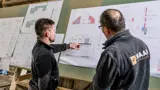 Twee mannen bekijken bouwplannen.